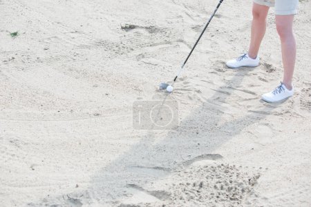 Photo for Woman holding golf stick on the sand field - Royalty Free Image