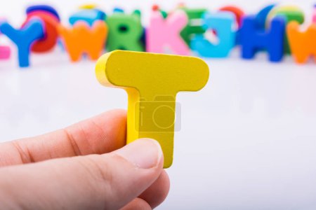 Photo for "Hand holding Letter cube  T of  Alphabet" - Royalty Free Image