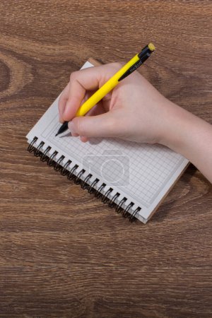Photo for Hand writing in a Notebook on brown background - Royalty Free Image