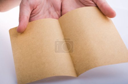 Photo for "Hand holding a brown color paper" - Royalty Free Image