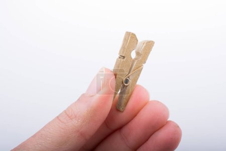 Photo for Hand holding a small wooden clothespin - Royalty Free Image