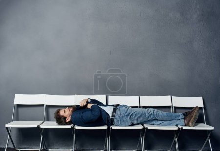 Foto de "Un hombre yace en sillas esperando una entrevista de trabajo gerente profesional" - Imagen libre de derechos