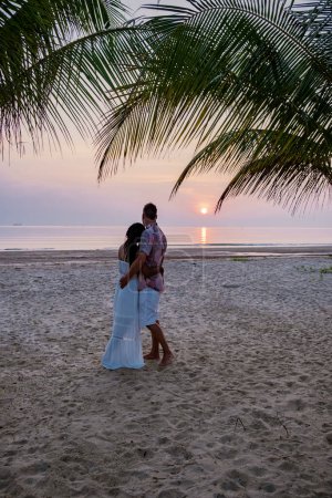 Sonnenaufgang am Strand mit Palmen, Chumphon Thailand, Paar beobachtet Sonnenuntergang am Strand in Thailand