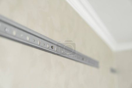 Photo for "Close-up of stainless steel mounting rail for mounting kitchen cabinets on a wall." - Royalty Free Image