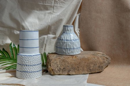 Photo for "Two white handmade ceramic vases on white textured table cloth. " - Royalty Free Image