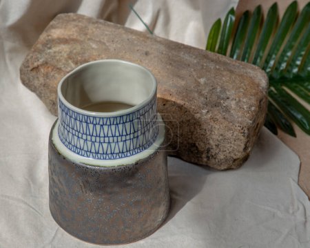 Téléchargez les photos : "Vase en céramique fait à la main sur nappe texturée blanche. " - en image libre de droit