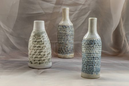 Foto de "Tres hecho a mano forma de botella de jarrón de cerámica en Blush paño de tabla texturizado. " - Imagen libre de derechos