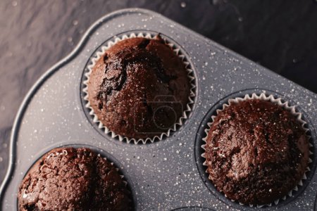 Téléchargez les photos : "Juste des muffins au chocolat cuits au four dans un plateau, recette maison de nourriture de confort" - en image libre de droit