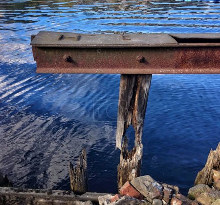 Photo for Rusty beam in blue water on background - Royalty Free Image
