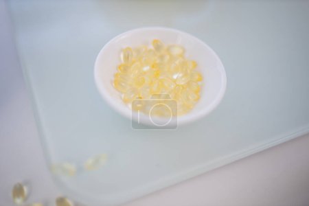 Photo for "Bowl of vitamin C pills on transparent cutting board" - Royalty Free Image
