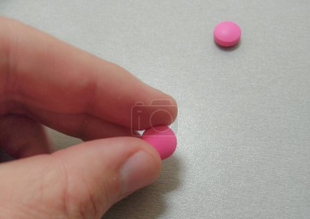 Photo for Pink pill and hand - Royalty Free Image