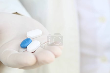 Photo for Hand in surgical glove holding pills - Royalty Free Image