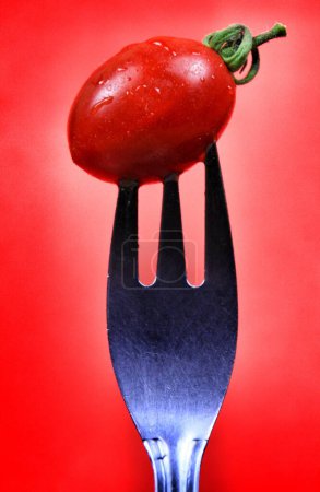 Foto de Tomate cherry pinchado en tenedor - Imagen libre de derechos