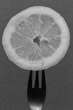 Photo for "Slice of lemon pricked on fork" - Royalty Free Image