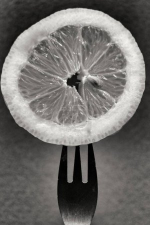 Photo for Slice of lemon pricked on fork - Royalty Free Image