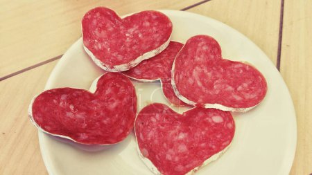 Téléchargez les photos : Slices of heart-shaped sausage on a plate - en image libre de droit