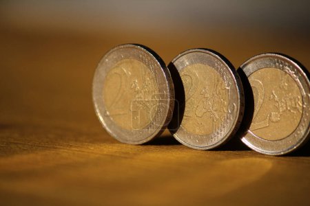 Foto de "Tres monedas de euro en tablero de madera" - Imagen libre de derechos