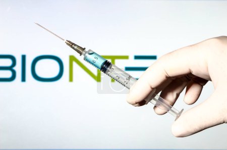 Photo for "Hand in surgery glove holding syringe with virus vaccine" - Royalty Free Image