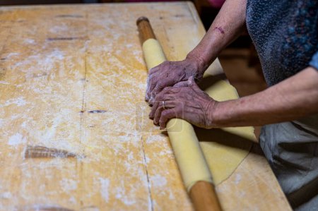 Photo for "detail roll out the dough with a rolling pin" - Royalty Free Image