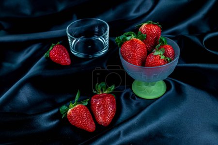 Foto de "taza de fresas maduras sobre fondo negro" - Imagen libre de derechos