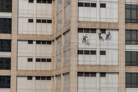 Photo for Group of workers cleaning windows service on high rise office building - Royalty Free Image