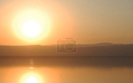 Téléchargez les photos : Majestueuse scène de coucher de soleil au bord de la mer avec fond de montagnes, Jordanie - en image libre de droit