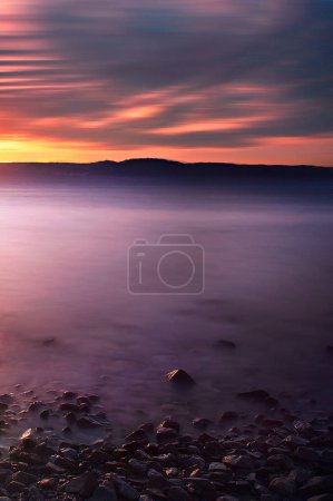 Téléchargez les photos : Paysage naturel de coucher de soleil au bord de la mer avec fond de montagnes, Jordanie - en image libre de droit
