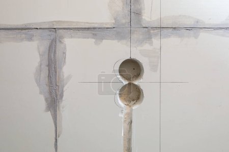 Photo for "Holes in the wall for sockets. Electrical wiring in the wall." - Royalty Free Image