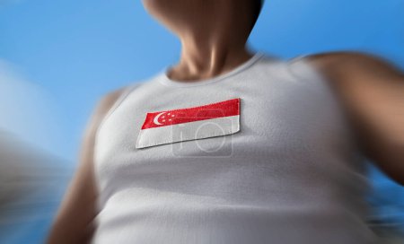 Téléchargez les photos : Le drapeau national de Singapour sur la poitrine de l'athlète - en image libre de droit