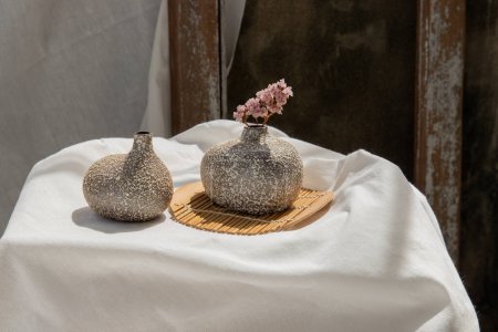 Téléchargez les photos : Fleurs séchées dans des vases en céramique double faits à la main sur la table. - en image libre de droit