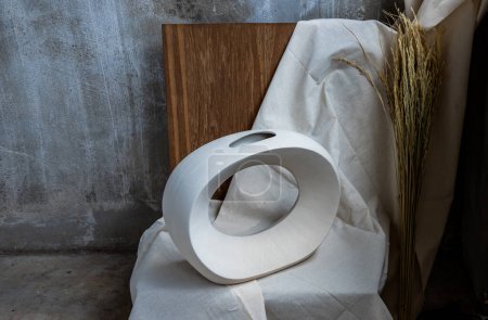 Téléchargez les photos : Beau vase blanc en céramique fait main sur chaise en bois. Décor de maison. - en image libre de droit