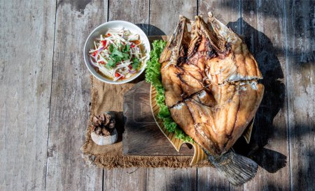 Photo for "Deep fried Snapper with fish sauce on vintage wooden." - Royalty Free Image