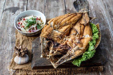 Photo for "Deep fried Snapper with fish sauce on vintage wooden." - Royalty Free Image