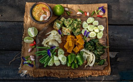 Téléchargez les photos : Thai Traditional Food : Shrimps chili dip or nam prik with shrimps (Nam Prik Goong Sod) with blanched vegetables and cha-om omelets on wooden backgroud - en image libre de droit