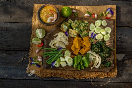 Téléchargez les photos : "Thai Traditional Food : Shrimps chili dip or nam prik with shrimps (Nam Prik Goong Sod) with blanched vegetables and cha-om omelets on wooden backgroud." - en image libre de droit