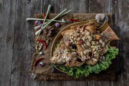 Photo for "Deep fried whole Tubtim fish with spicy lemongrass salad, Food for health." - Royalty Free Image