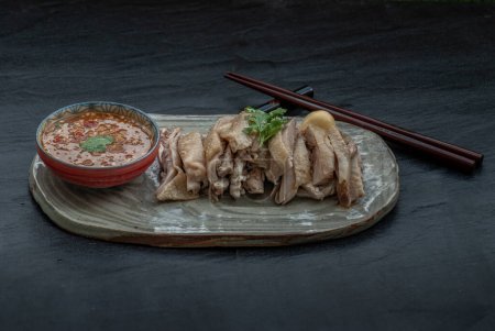 Foto de Asian food style marinated steamed chicken (Betong Chickken) and sauce on ceramic plate. Serving chilled as an appetizer. - Imagen libre de derechos