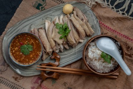 Foto de Asian food style marinated steamed chicken (Betong Chickken) with Rice and sauce on ceramic plate. - Imagen libre de derechos