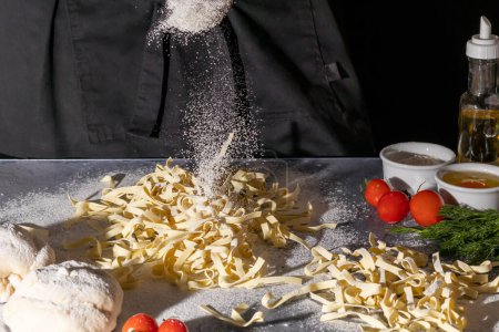 Téléchargez les photos : "Step by step instructions for making homemade noodles. The cook is cutting the dough. Wooden background." - en image libre de droit