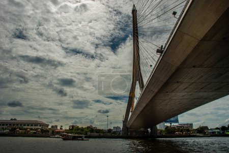 Photo for "Rama VIII bridge, Rope Bridge across the Chao Phraya River, A tall V-shape pylon tower with view blue sky is background, Cloudy day" - Royalty Free Image