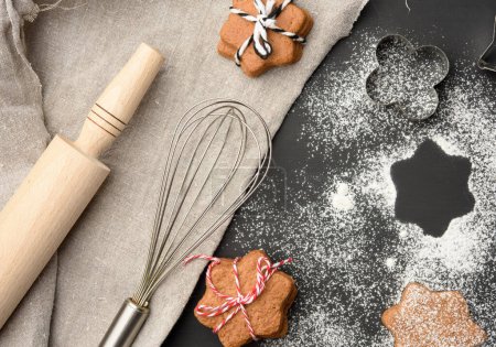 Foto de "Star shaped baked gingerbread cookies sprinkled with powdered sugar on a black table" - Imagen libre de derechos