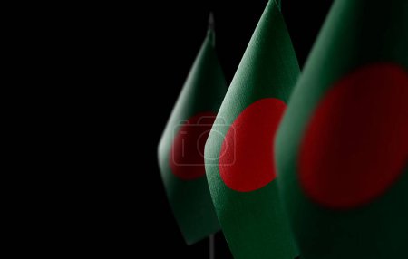 Foto de "Pequeñas banderas nacionales de Bangladesh sobre un fondo negro" - Imagen libre de derechos