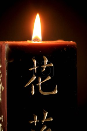 Photo for "Black candle with japanese letters on black background" - Royalty Free Image
