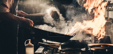 Téléchargez les photos : "Chef faire frire la cuisson occupée dans la cuisine" - en image libre de droit
