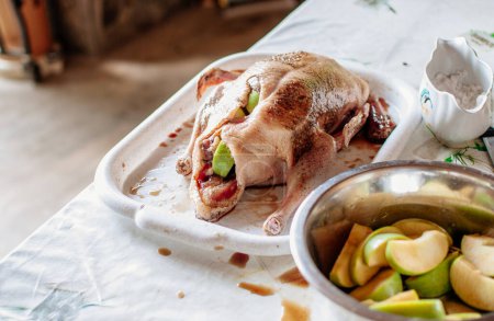Foto de "Whole duck fresh and raw on a tray with ready-made ingredients and spices. Peking Duck Dressed with Apple Filling Recipe Concept." - Imagen libre de derechos