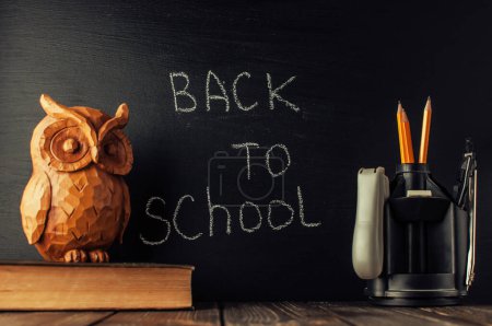 Photo for Back to school, the concept of parenting. The inscription on the blackboard with white chalk, next is the owl on the book. Place for text. Copy space. - Royalty Free Image