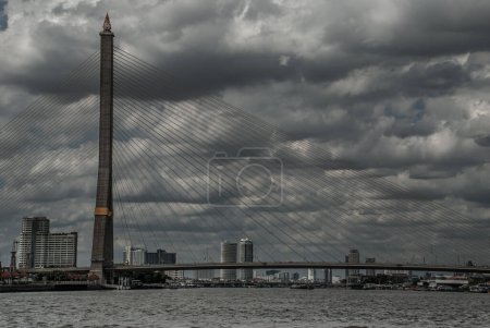 Photo for "Rama VIII bridge, Rope Bridge across the Chao Phraya River of view blue sky is background and Cityscape of Bangkok." - Royalty Free Image