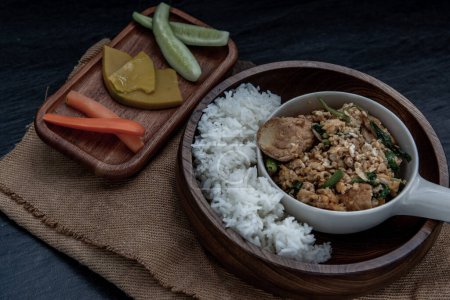 Téléchargez les photos : "Thai food, Stir fried egg tofu with spring onion with Herbs vegetables served with steamed rice in wooden bowl." - en image libre de droit