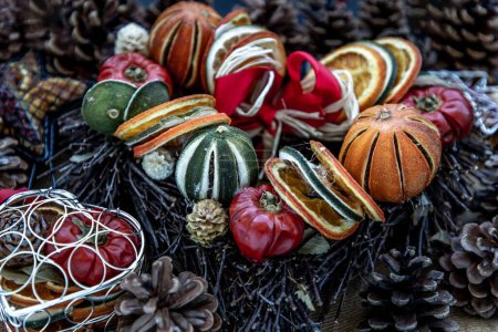 Foto de "Decoración de Navidad. Árbol de Navidad de ramitas, conos de pino natural marrón y variedad de frutas sobre fondo de tela de arpillera." - Imagen libre de derechos