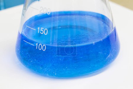 Téléchargez les photos : Liquide bleu dans une fiole contenant des sédiments - en image libre de droit
